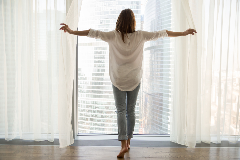 Start the day peacefully Woman that opens the curtains